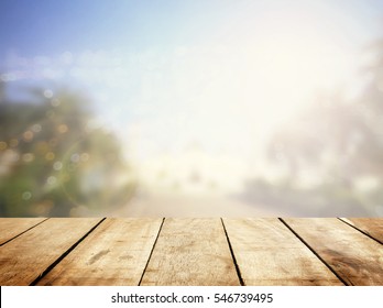 Wood table bar texture front window blurry bokeh outside garden calm view. Summer rustic kitchen stage, breakfast promotion presentation. mosque landscape place grunge spring board, Urban city scape.