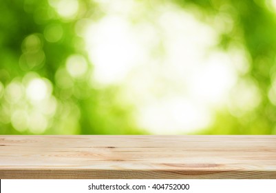 Wood Table Top And Blur Of  Fresh Green Bokeh From Garden Background .For Product Display And Natural Concept