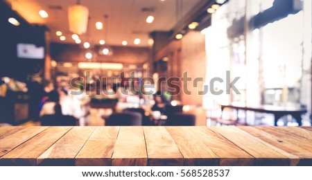 Wood table top with blur of people in coffee shop or (cafe,restaurant )background.For montage product display or design key visual layout