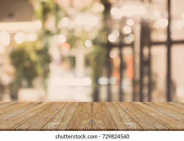 Wood table top and blurred bokeh cafe and coffee shop interior background with vintage filter - can used for display or montage your products. - Shutterstock ID 729824560