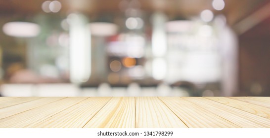 Wood table top with Cafe Restaurant interior with bar counter blur abstract background with bokeh light - Shutterstock ID 1341798299