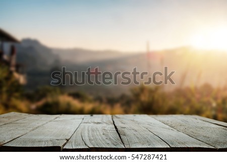 Wood table top in front of of trees in the forest. blur background image, for product display montage.
