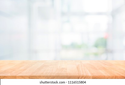 Wood table top on blur white glass wall background form office building.For montage product display and design key visual layout - Shutterstock ID 1116515804