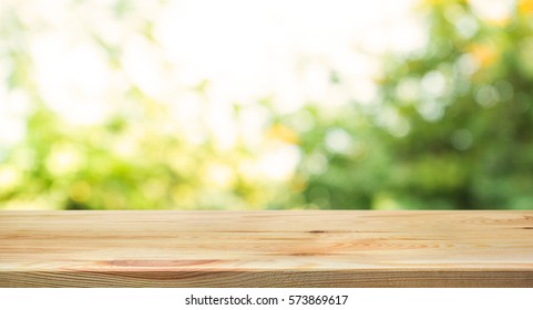 Wood Table Top On Blur Abstract Green From Garden In The Morning Background.For Montage Product Display Or Design Key Visual Layout