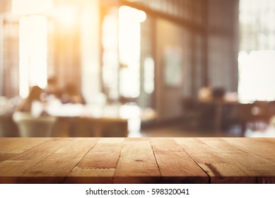 Wood table top on blur restaurant (cafe) interior background - can be used for display your products or foods