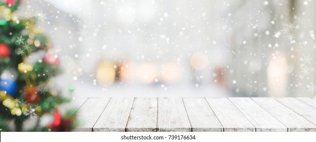 Wood Table Top On Blur With Bokeh Christmas Tree Background With Snowfall - Can Be Used For Display Or Montage Your Products.