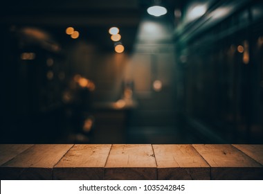 Wood table top on blurred of counter cafe shop with light bulb.Background for montage product display or design key visual layout.