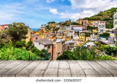 Wood Table Top On Blurred Background Of Manarola Village On Cliff Rocks And Sea At Sunset.Seascape In Five Lands, Cinque Terre ,Italy Europe.vintage Tone Color,can Be Used Display Your Products