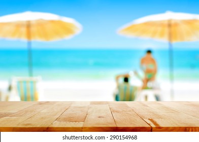 Wood Table Top On Blurred White Sand Beach Background With Some People - Can Be Used For Montage Or Display Your Products