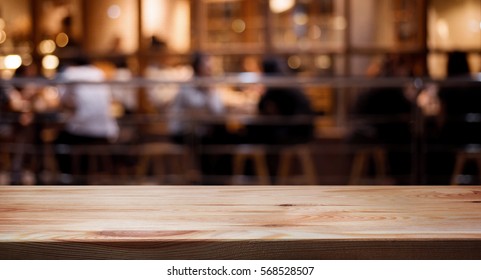 Wood Table Top On Blurred Of Cafe ( Restaurant ) With Light Gold In Dark Nigh Background.panoramic Banner