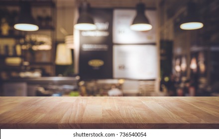 Holztisch oben auf unscharfem Counter-Café-Shop mit hellbraunem Hintergrund.Für die Montage von Produkten-Display oder Design-Key-visuellen Layout.