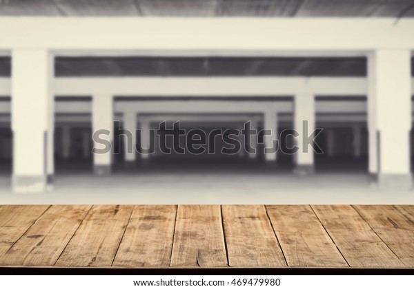Wood tabletop\
with blurry restaurant building car park for product display or\
advertising montage your\
job.