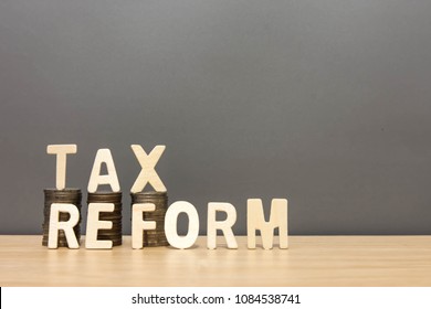 Wood  tax reform word and money coin stack on wooden table background.concept tax payments will be change.