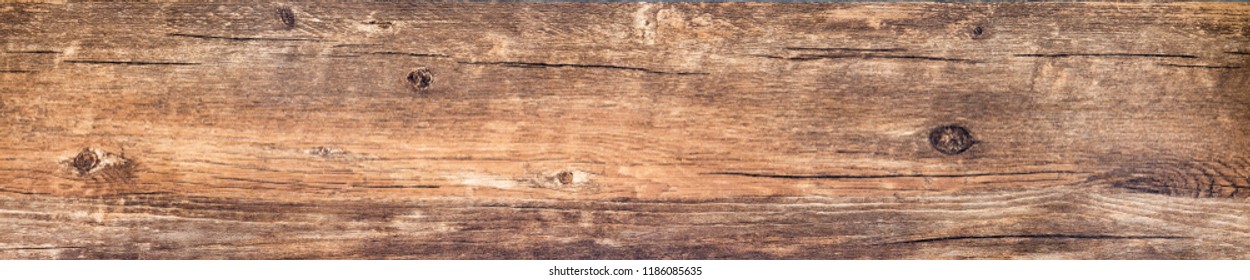 Wood Texture Background, Rough Wooden Plank With Nature Color, Cracks And Woodgrain. Old Weathered Knotted Long Board From Rustic Barn Close-up. Horizontal Brown Banner With Vintage Wood Pattern.