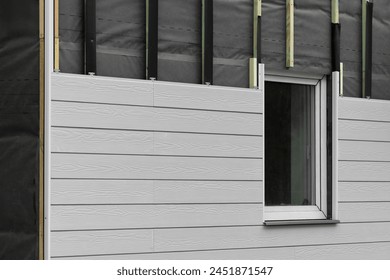 wood texture composite cladding installation on house facade. WPC exterior wall siding panels