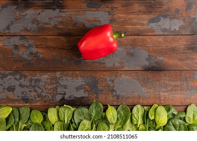 wood texture with vegetables, red pepper, cherry tomatoes, cucumber, spinach, red onion, top view