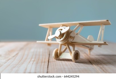 wood toy airplane on wood table with blue clean background.