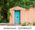 Wood turquoise colored door set in an old adobe wall in Santa Fe, New Mexico