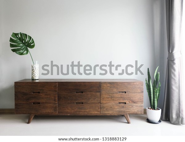 Wood TV cabinet interior wall Mockup\
with small plant tropical style in living room place with free\
space in center of picture for present the product.\
image\
