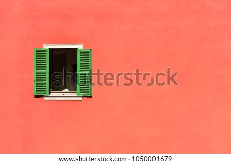 An wood vintage window with green shutters on the plastered stone wall in italian style.