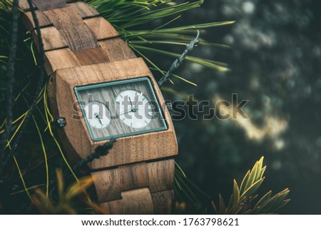 Wood watch in outdoors with backgrond of plants