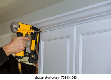 Wood Working Using Brad Nail Gun To Crown Moulding On White Kitchen Cabinets Framing Trim,