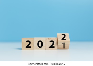 woodblocks cubes with a number 2021 change to 2022 blue background. new year 2021- 2022 concept. 