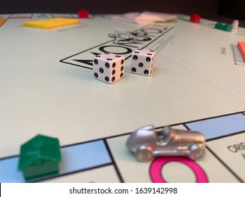 WOODBRIDGE, NEW JERSEY / UNITED STATES - January 17, 2020: Dice And Games Pieces Sit On An Old Monopoly Board In This Illustrative Editorial Image