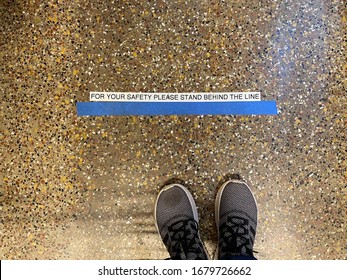 WOODBRIDGE, NEW JERSEY / USA - March 20, 2020: A line on the floor warns shoppers to stand behind the line at the checkout, to keep social distancing during the coronavirus pandemic. Illustrative