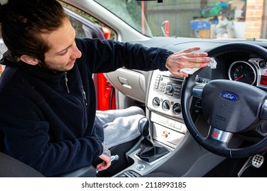 Woodbridge, Suffolk, UK February 24 2021: A Young Adult Man Cleaning Out His Car. Cleaning Out The Rubbish And Wiping Away The Dirt And Grime