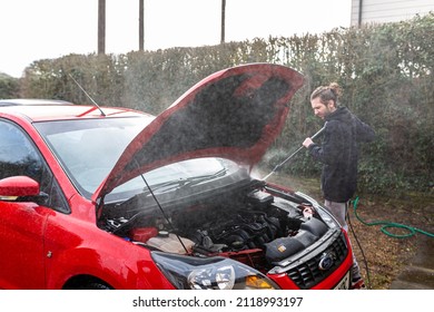 Woodbridge, Suffolk, UK February 24 2021: A Young Man Pressure Washing His Car Clean