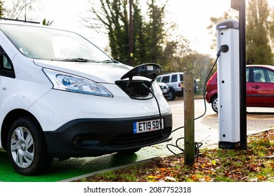 Woodbridge Suffolk UK November 28 2021: Nissan E-NV200 Electric Van Charging At Plug In Charge Station In A Public Car Park In Suffolk, UK