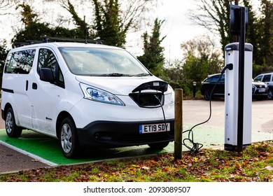 Woodbridge Suffolk UK November 28 2021: Nissan E-NV200 Electric Van Charging At Plug In Charge Station In A Public Car Park In Suffolk, UK