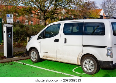 Woodbridge Suffolk UK November 28 2021: Nissan E-NV200 Electric Van Charging At Plug In Charge Station In A Public Car Park In Suffolk, UK