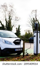 Woodbridge Suffolk UK November 28 2021: Nissan E-NV200 Electric Van Charging At Plug In Charge Station In A Public Car Park In Suffolk, UK