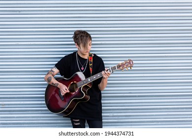 Woodbridge, Suffolk, UK September 20 2020: A 20 Something Female Relaxing And Playing An Acoustic Guitar Outside For Passers By To Listen Too