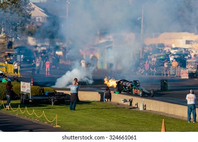 WOODBURN, OR - SEPTEMBER 27, 2015: Darin Bay's Warped Speed Black Rat Jet Dragster Blows Fire And Smoke Towards Spectators During The NHRA 30th Annual Fall Classic At The Woodburn Dragstrip.