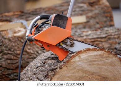 Woodcutter saws tree with electric chain saw on sawmill. Chainsaw used in activities such as tree felling, pruning, cutting firebreaks in wildland fire suppression, and harvesting of firewood. - Shutterstock ID 2250074031