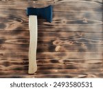 A wood-cutting axe on the wooden table. The edge is covered with rubber guard