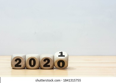 Wooden 2020 to 2021 new year white background. 
Word 2020 & 2021 wood cube on wooden desk for copy space. 