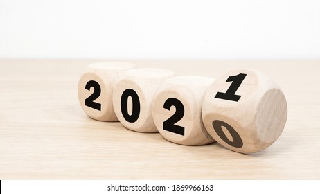 Wooden 2020 to 2021 new year white background. 
Word 2020 - 2021 wood cube on wooden desk for copy space. 