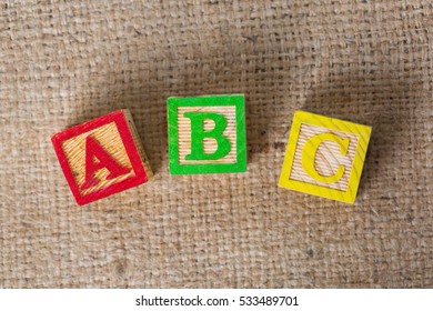 Wooden ABC Blocks On Sack Background.