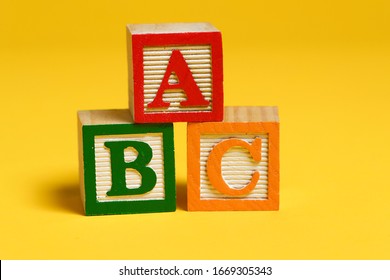 Wooden ABC Blocks On Yellow Background