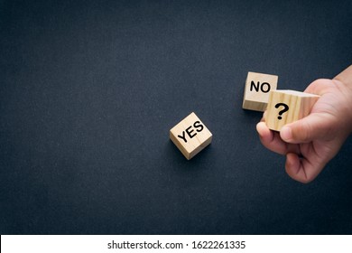 Wooden alphabet cube with words YES or NO closeup and children hands on black background. Selective focus and education concept - Shutterstock ID 1622261335