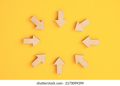 Wooden arrows point on yellow background. Space for your text