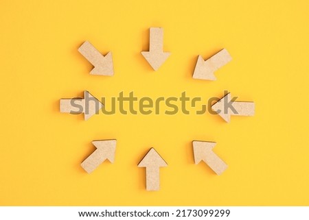 Wooden arrows point on yellow background. Space for your text