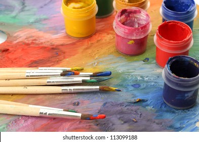 wooden art palette with paint and brushes, close up - Powered by Shutterstock