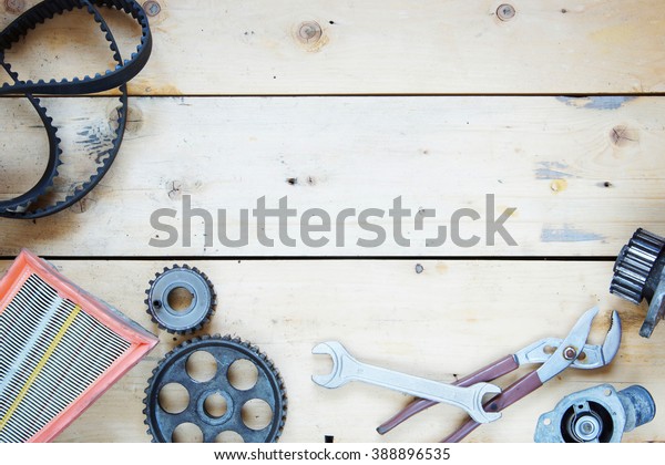 Wooden background\
with automobile spare\
parts