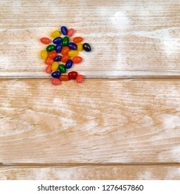 Wooden Background With Jelly Beans In One Corner And Copy Space..