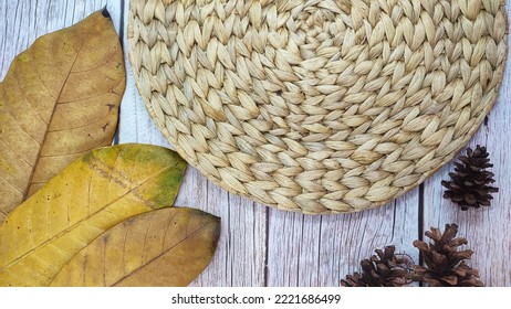 Wooden Background With Rattan Plate And Dried Leaves